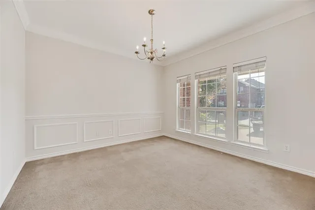 en empty room with windows and chandelier