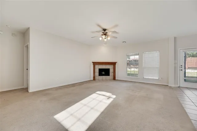an empty room with windows and fireplace