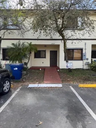 a view of a house with patio next to a yard