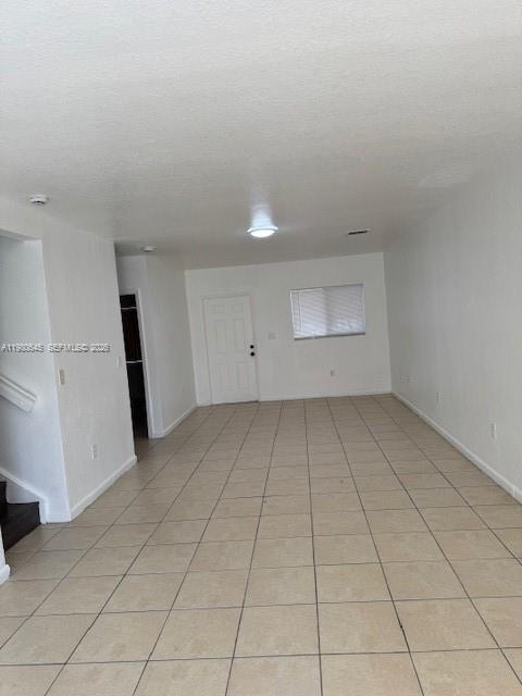 28107 Southwest 143rd Court, Unit 28107 Homestead, FL 33033 - Photo 3 of 10 an empty room with white walls and tiles