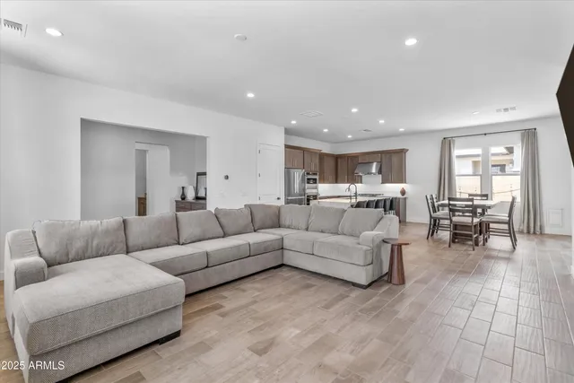 a living room with furniture and a dining table with kitchen view