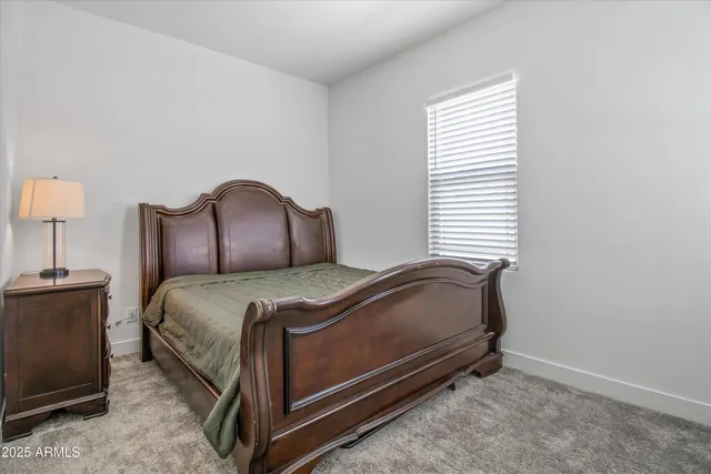 a bedroom with a bed and a lamp on dresser