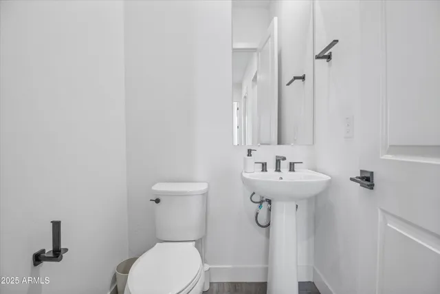a bathroom with a sink toilet and a mirror