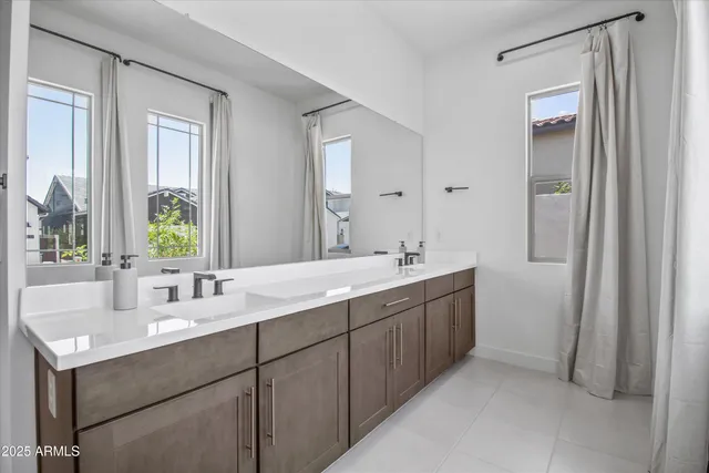 a bathroom with double sink and a mirror