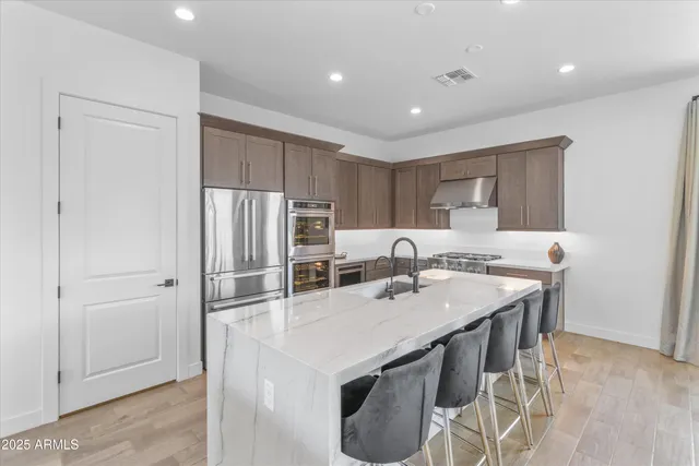 a kitchen with kitchen island a sink table and chairs