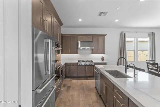 a kitchen with stainless steel appliances granite countertop a sink stove and refrigerator