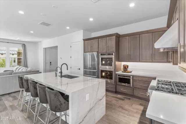 a kitchen with kitchen island a sink stove and refrigerator