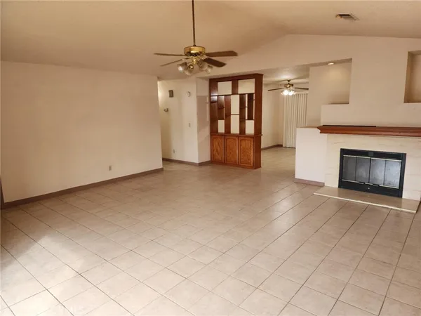an empty room with fireplace and windows