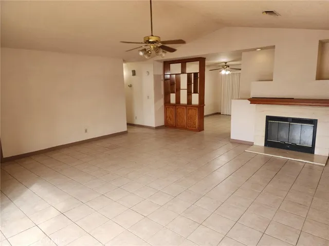 an empty room with fireplace and windows