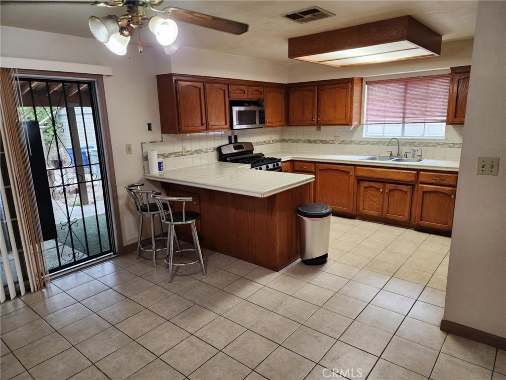 725 18th Place Delano, CA 93215 - Photo 15 of 36 a kitchen with stainless steel appliances granite countertop a stove a sink dishwasher and a refrigerator with cabinets
