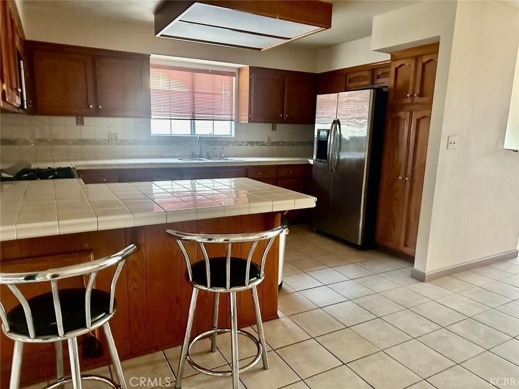 725 18th Place Delano, CA 93215 - Photo 16 of 36 a kitchen with stainless steel appliances kitchen island granite countertop a table chairs in it and wooden floors