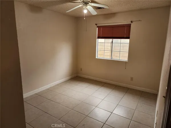 an empty room with a ceiling fan and window