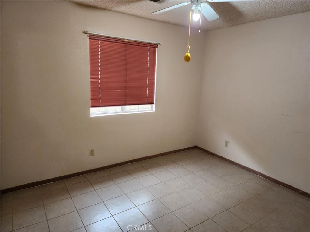 725 18th Place Delano, CA 93215 - Photo 21 of 36 an empty room with a chandelier fan