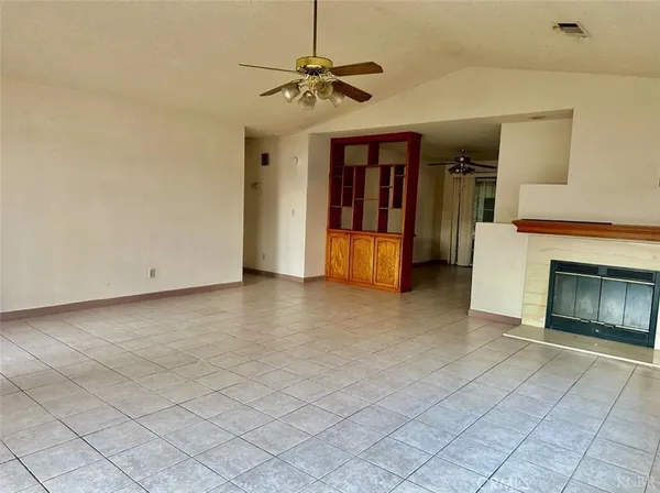 a view of a livingroom with a ceiling fan and a fireplace