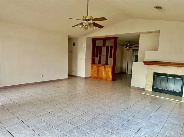 a view of a livingroom with a ceiling fan and a fireplace