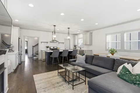 a living room with lots of furniture and kitchen view