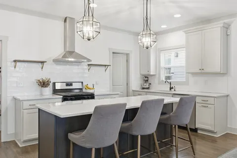 a kitchen with stainless steel appliances a kitchen island a stove a table and chairs in it