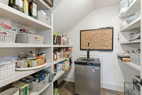 a bedroom with a bed potted plant on the dresser and a window