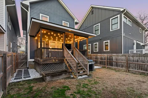 a view of an house with a small yard and wooden fence