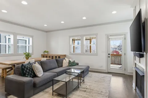 a living room with furniture a flat screen tv and a window