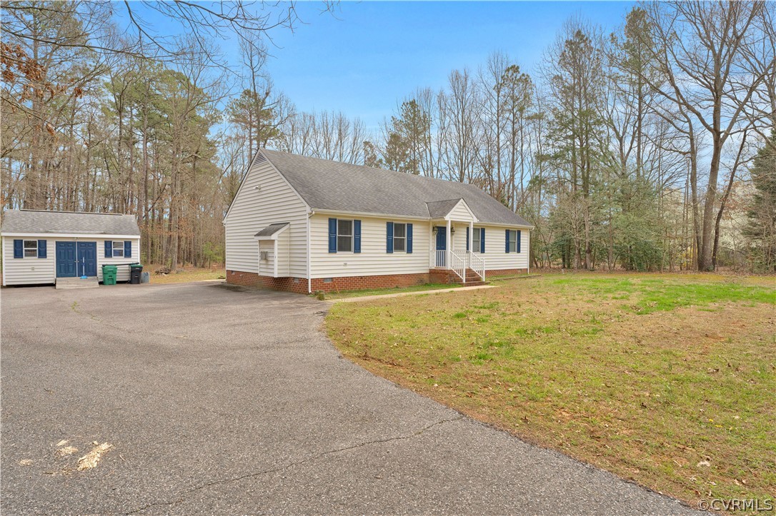 8561 Roundabout Road Henrico, VA 23231 - Photo 18 of 42 a front view of a house with a yard and trees