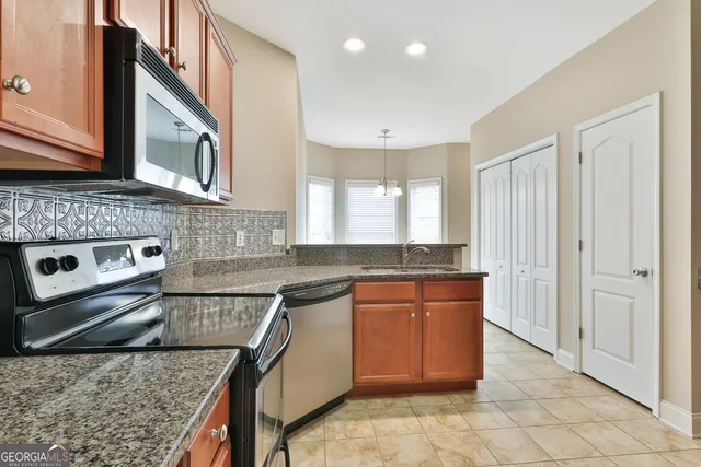a kitchen with stainless steel appliances granite countertop a stove a sink and a microwave