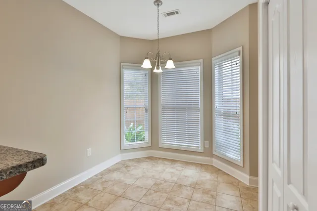 a view of a livingroom with a chandelier fan and windows