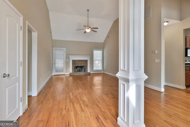 a view of empty room with wooden floor and fireplace