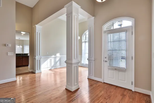 a view of empty room with wooden floor and fan