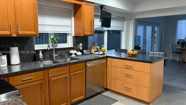 a kitchen with stainless steel appliances granite countertop a sink a stove and cabinets