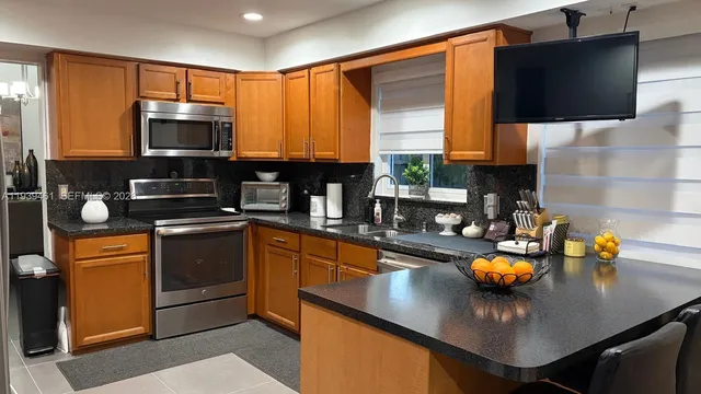 a kitchen with stainless steel appliances a stove sink microwave and cabinets
