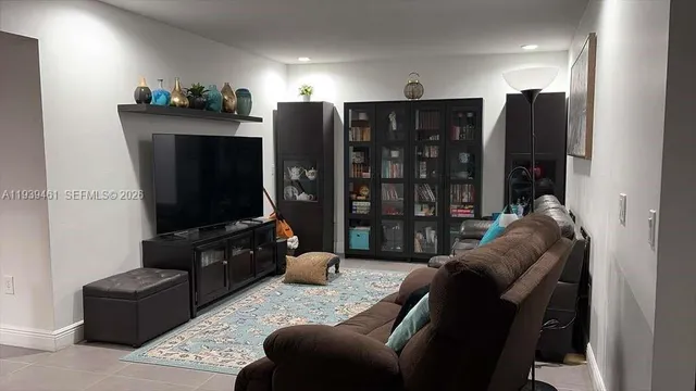 a living room with furniture a lamp and a flat screen tv