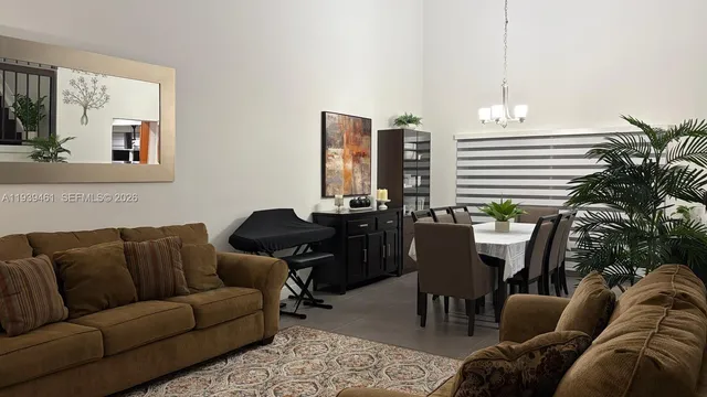 a living room with furniture kitchen view and a potted plant