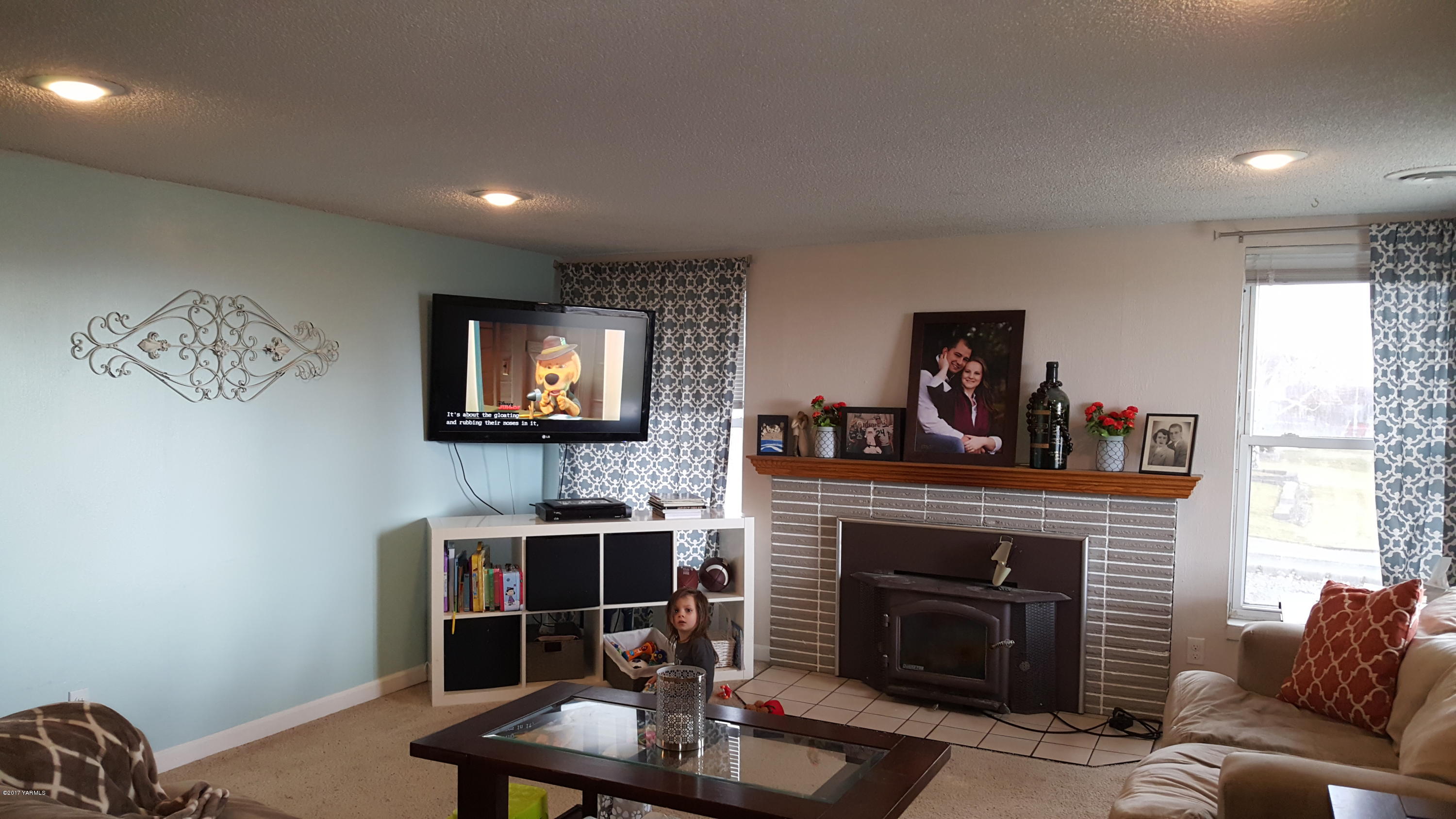 1809 Ekelman Road Yakima, WA 98901 - Photo 5 of 15 a living room with furniture a fireplace and a flat screen tv