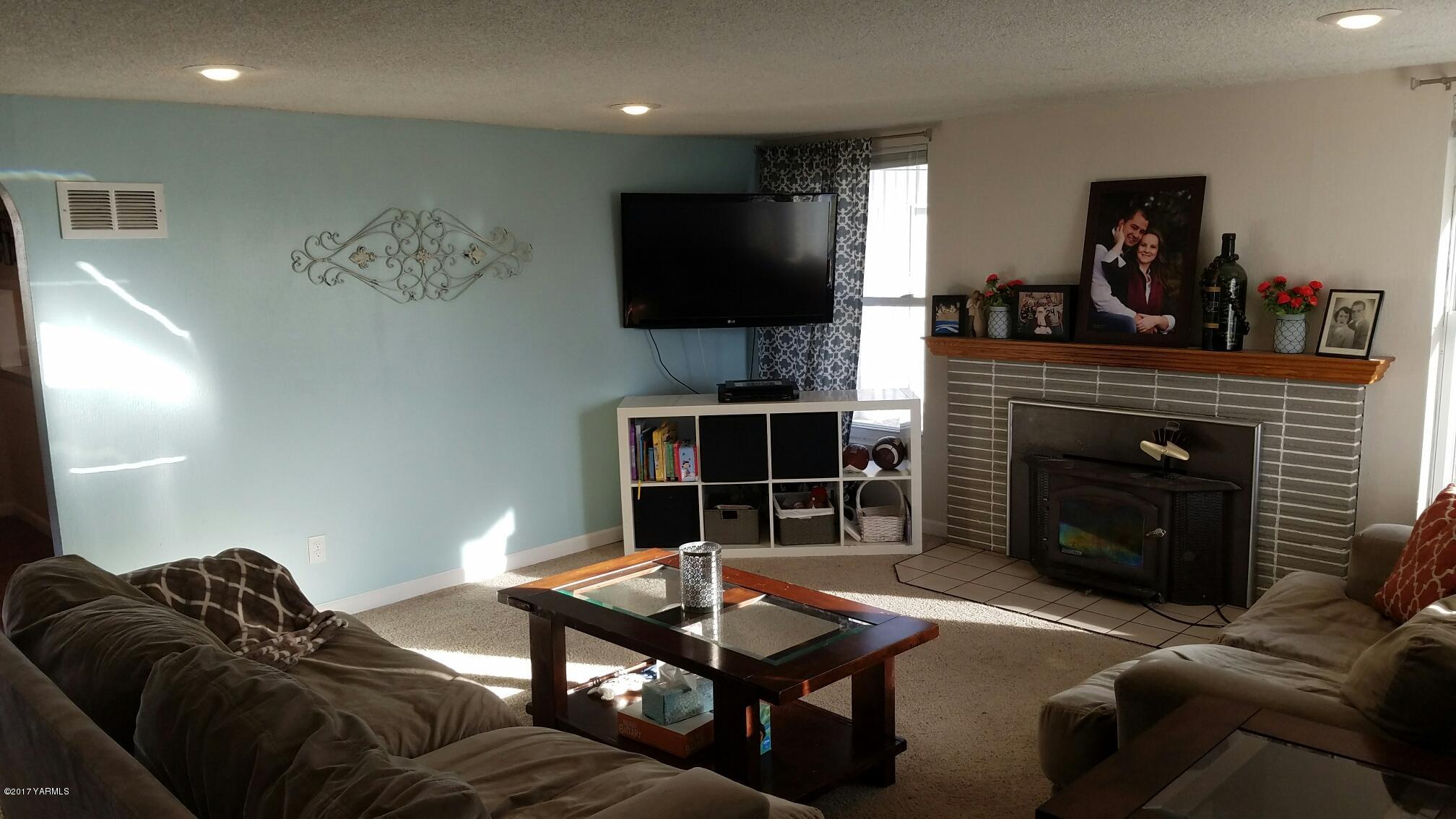 1809 Ekelman Road Yakima, WA 98901 - Photo 10 of 15 a living room with furniture a flat screen tv and a fireplace
