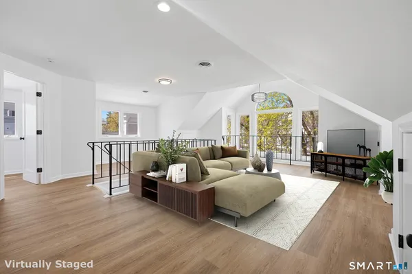 a living room with furniture and a wooden floor