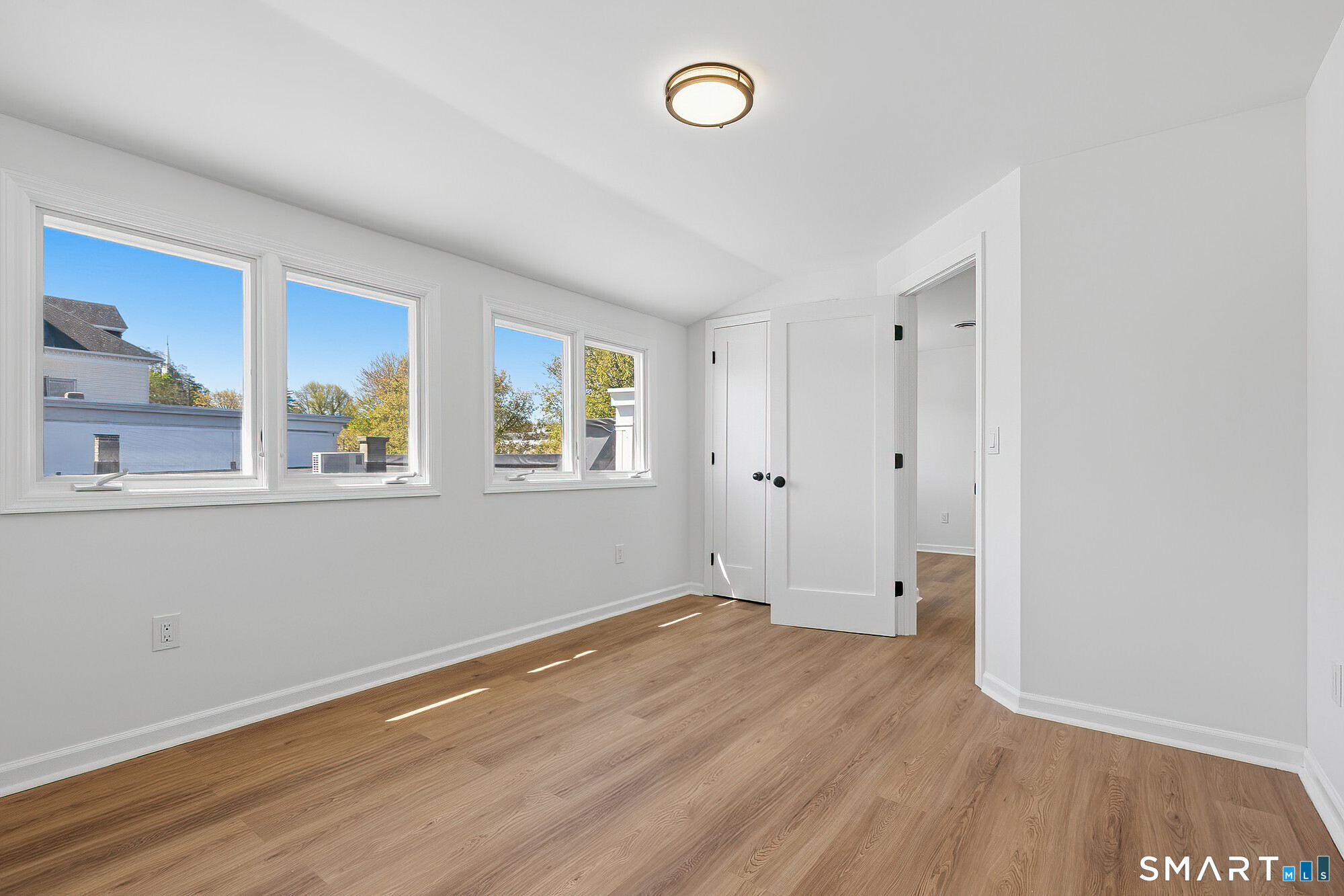 426 Main Street, Unit G Ridgefield, CT 06877 - Photo 13 of 24 an empty room with a window and wooden floor