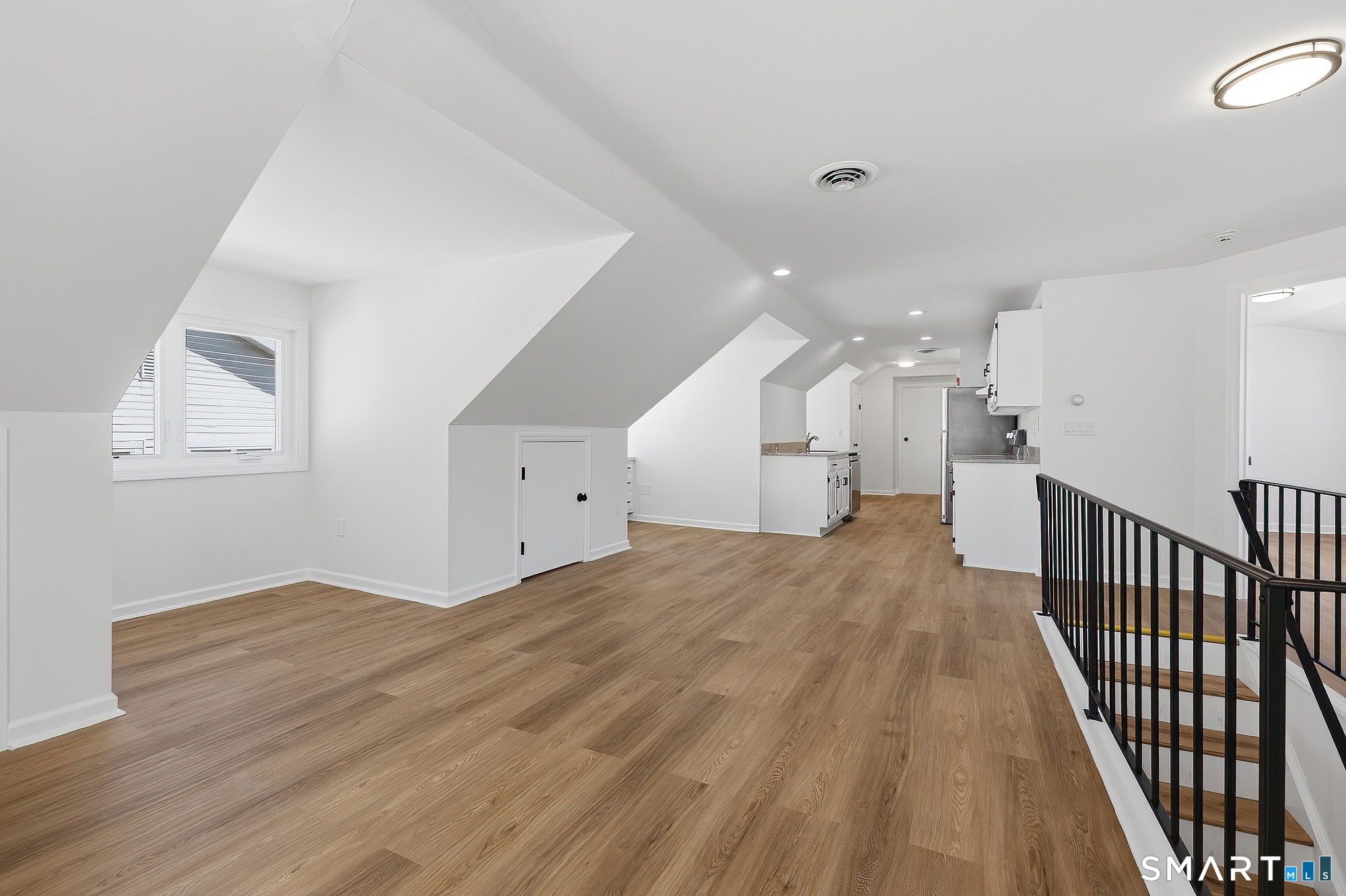 426 Main Street, Unit G Ridgefield, CT 06877 - Photo 3 of 24 a view of a hallway with wooden floor and windows
