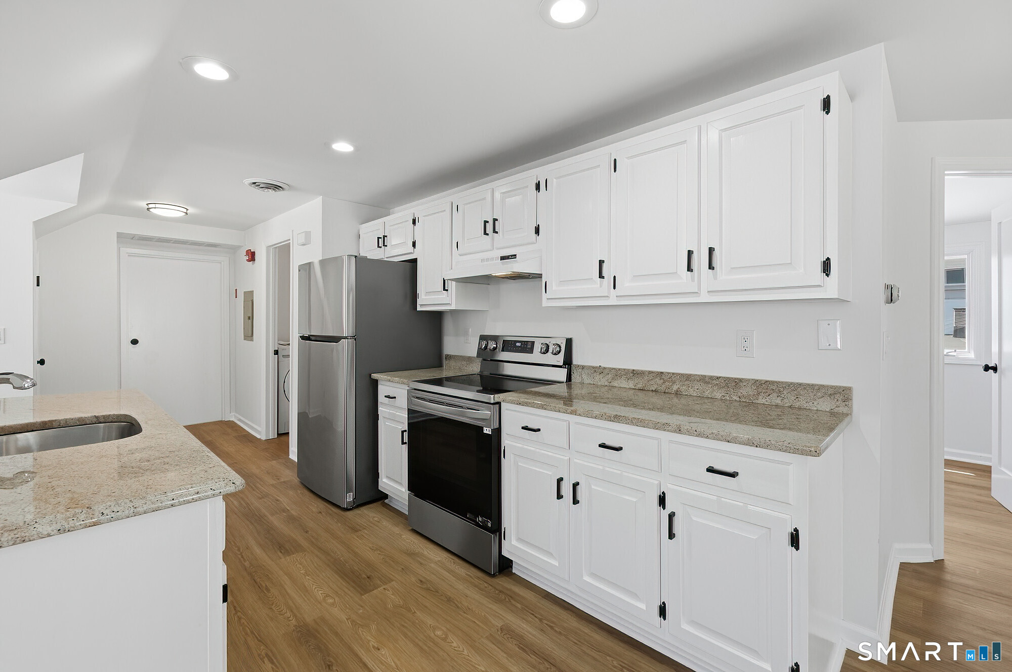426 Main Street, Unit G Ridgefield, CT 06877 - Photo 4 of 24 a kitchen with granite countertop white cabinets and stainless steel appliances