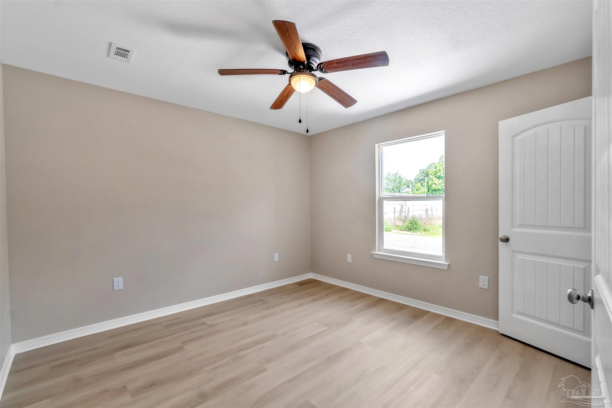 50 Fulton Avenue Pensacola, FL 32503 - Photo 15 of 22 an empty room with wooden floor ceiling fan and windows