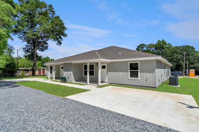 a front view of a house with a yard and trees