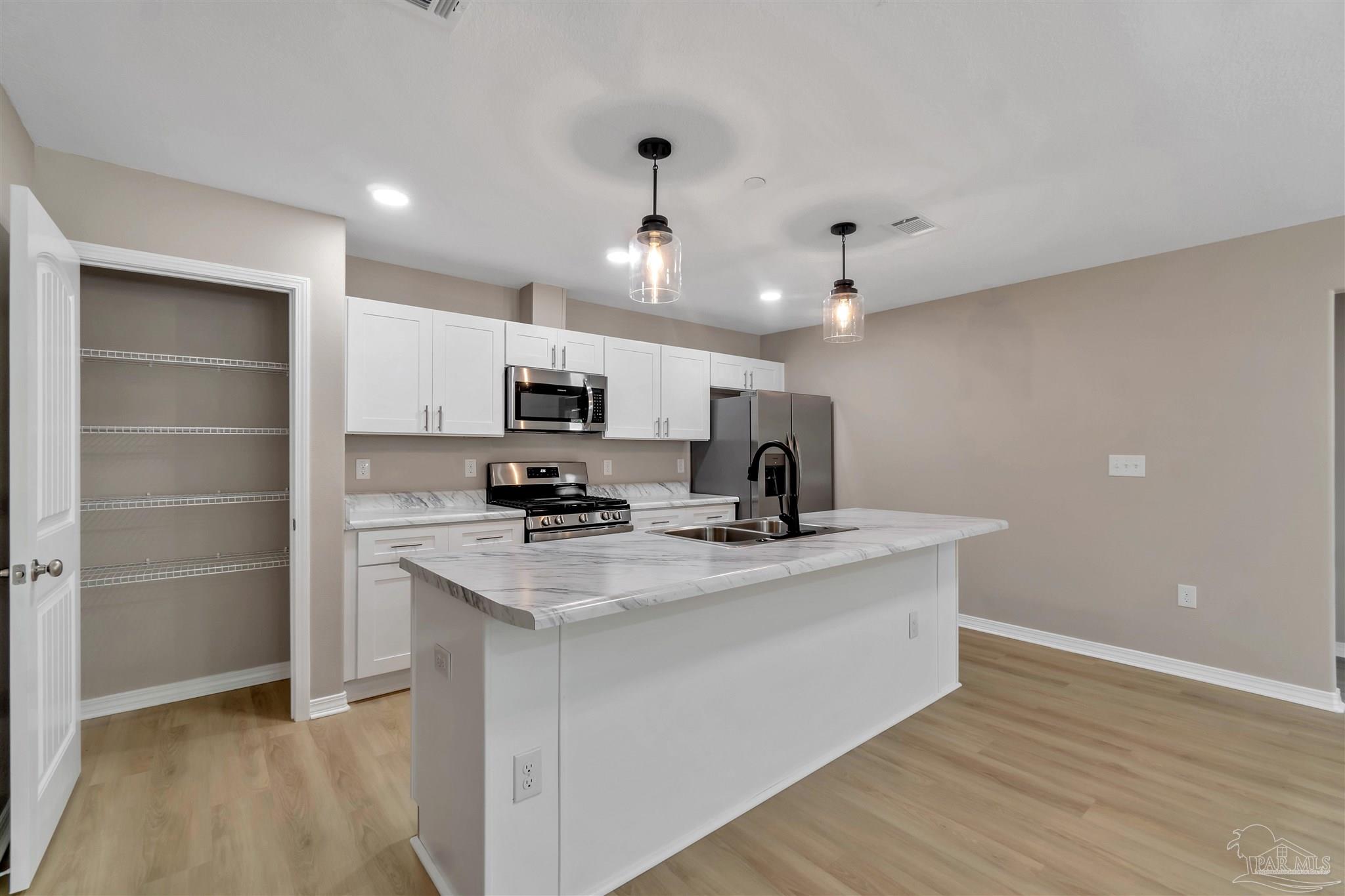 50 Fulton Avenue Pensacola, FL 32503 - Photo 5 of 22 a kitchen with stainless steel appliances a sink stove and refrigerator
