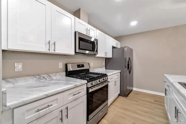 a kitchen with stainless steel appliances granite countertop a stove a refrigerator and a microwave