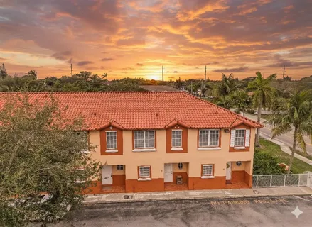 a view of a white house next to a yard and lake
