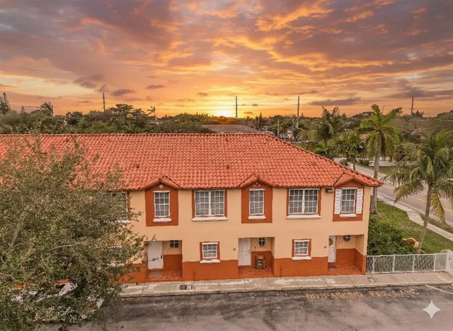 a view of a white house next to a yard and lake