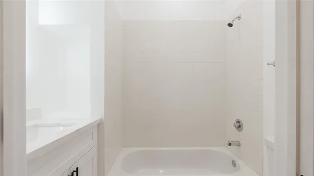 a bathroom with a bathtub sink vanity and mirror