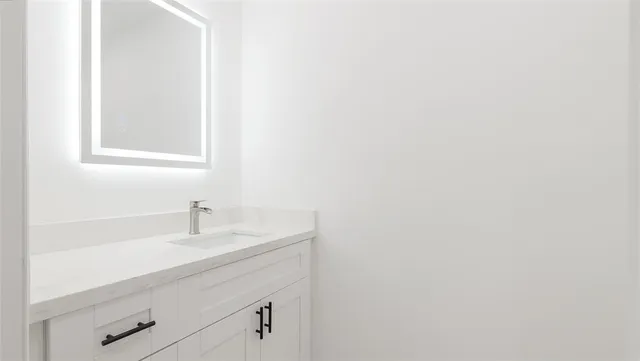 a bathroom with a sink vanity and mirror