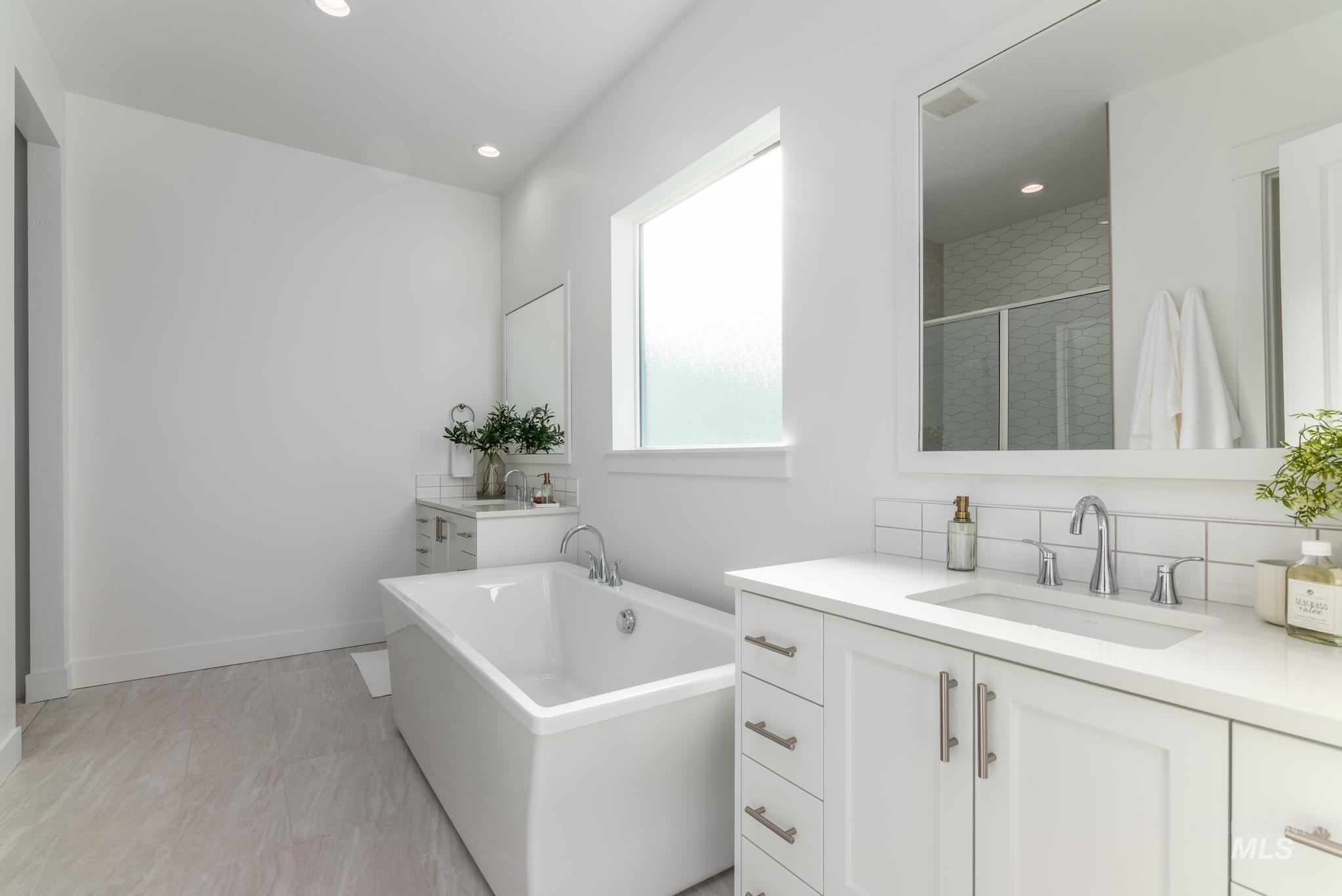 5318 Sparky Avenue Caldwell, ID 83607 - Photo 7 of 11 Full bath featuring a stall shower, two vanities, a freestanding tub, and recessed lighting