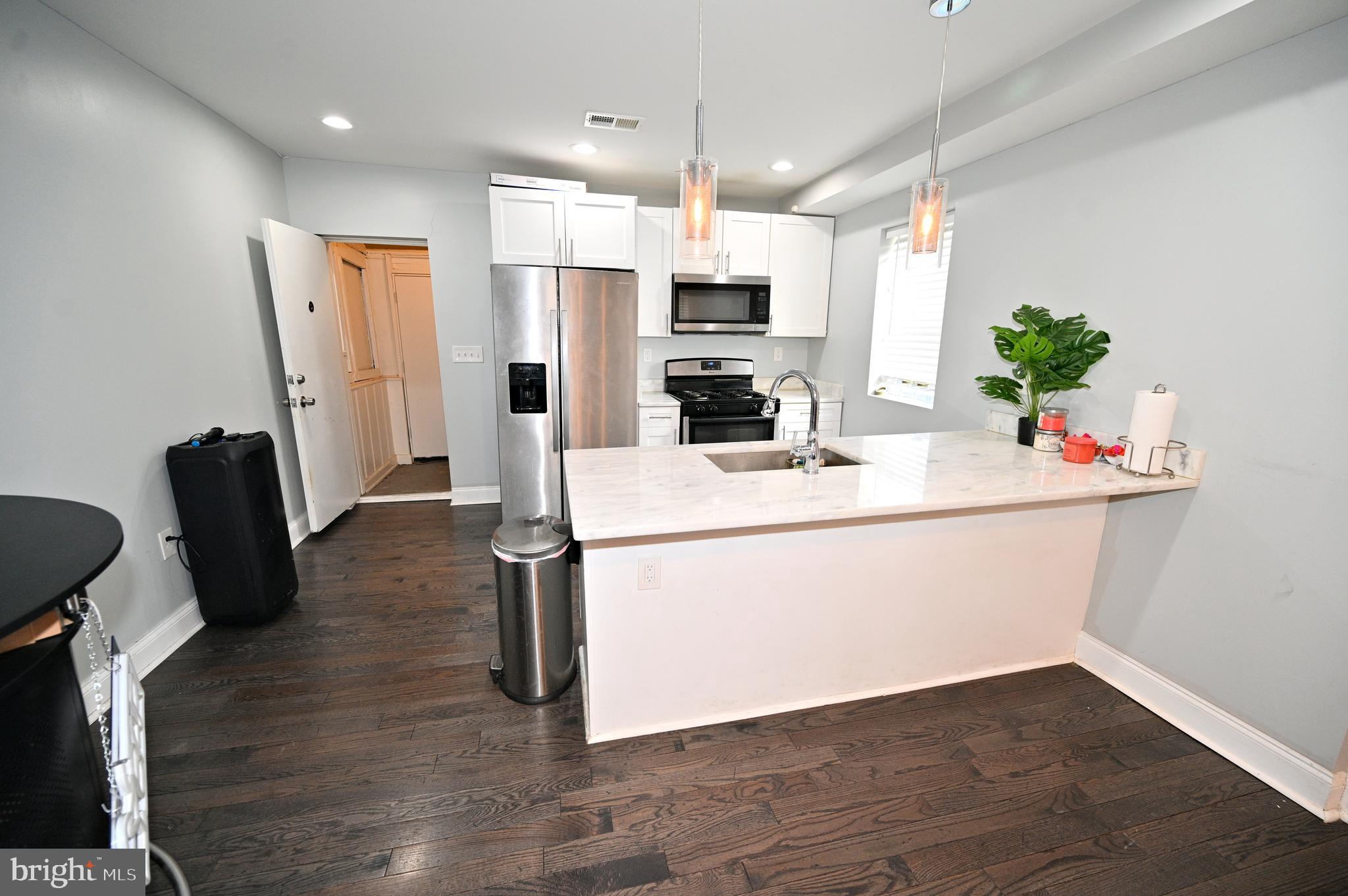 3700 Flowerton Road Baltimore, MD 21229 - Photo 10 of 30 a kitchen with stainless steel appliances a refrigerator sink stove microwave and cabinets