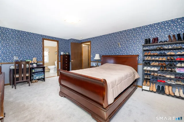 a spacious bedroom with a bed and a large mirror